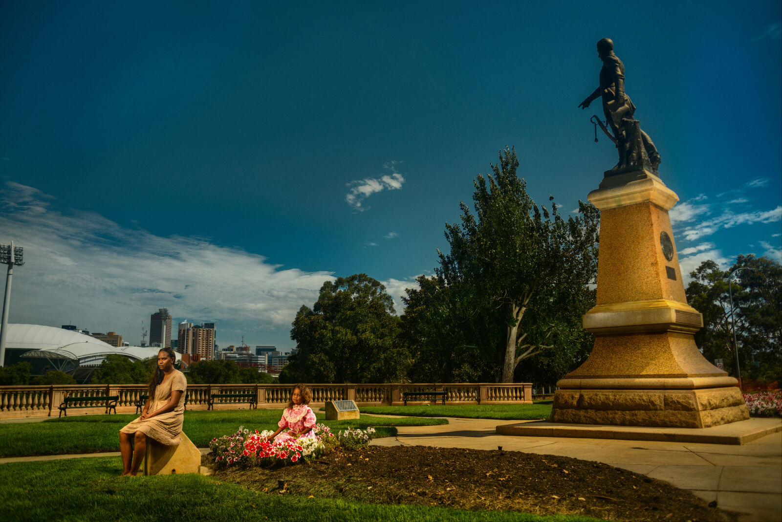 Mother and child in an Adelaide park beside a colonial statue