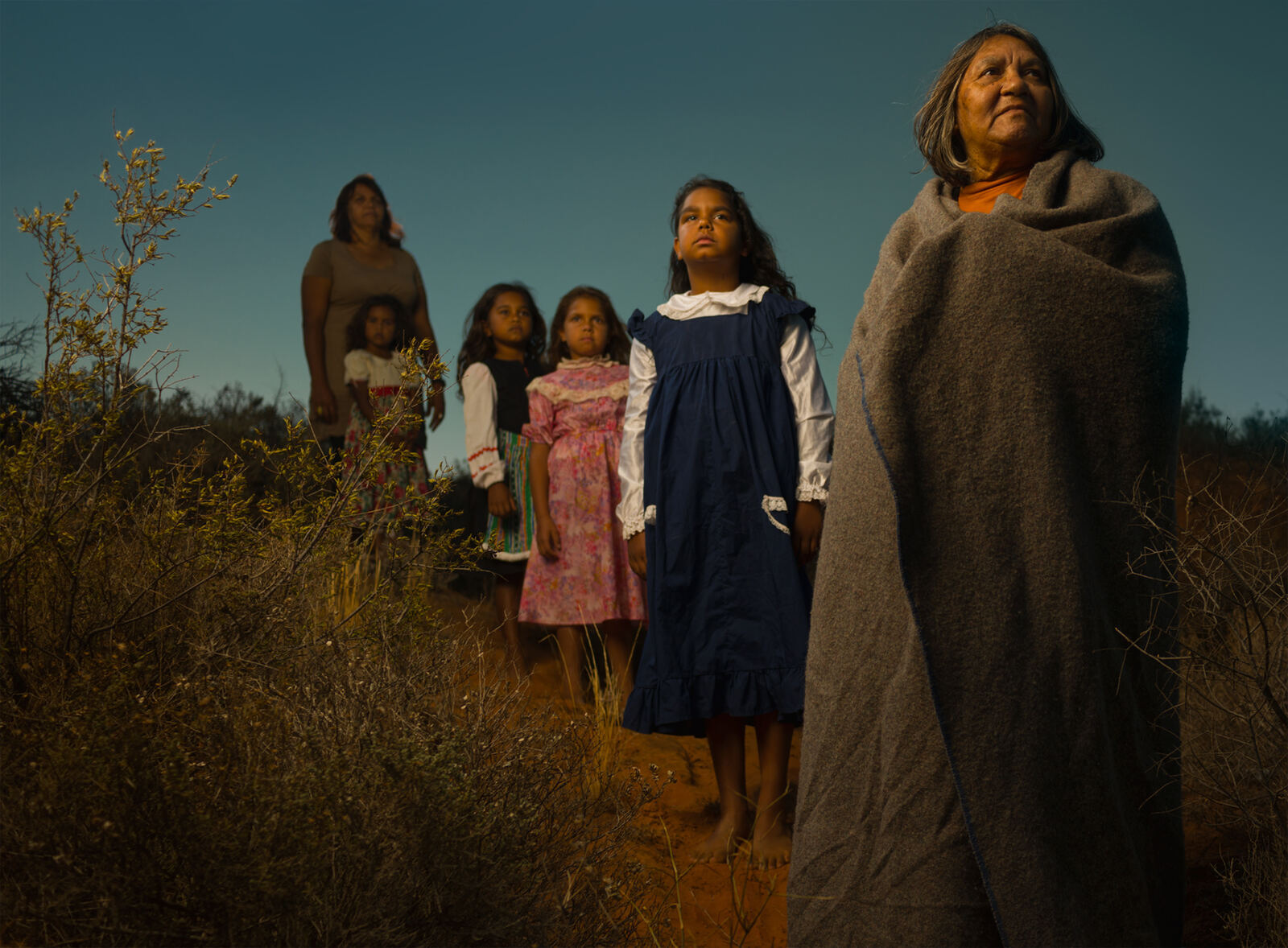 An Elder and young girls standing on Country